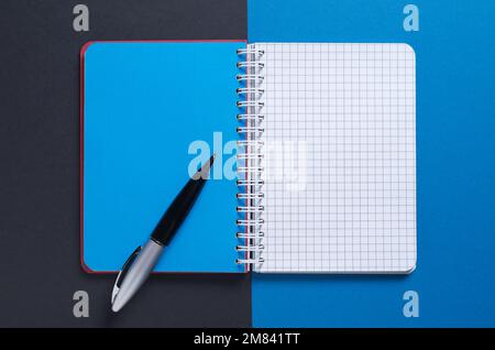Notebook e penna aperti su sfondo a due toni, vista dall'alto Foto Stock