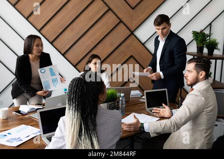 incontro di lavoro di uomini d'affari in un grande desktop con computer portatili Foto Stock