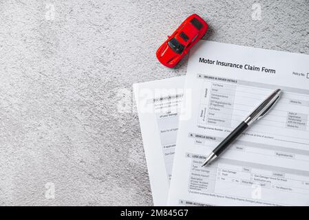 Modulo di richiesta di assicurazione auto o motore con penna a sfera e modello di auto Foto Stock