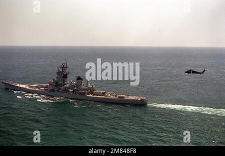 Un'elevata vista del quarto porto della nave da guerra USS IOWA (BB-61) in corso durante l'esercizio Ocean Safari '85. Un elicottero SH-60B Sea Hawk si avvicina alla poppa della nave. Soggetto operativo/Serie: OCEAN SAFARI '85 Paese: Oceano Atlantico settentrionale Foto Stock