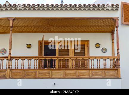 Chiusura del balcone con baldacchino in legno, ringhiera e tenda parasole orizzontale su persiane di porte e finestre. Foto Stock
