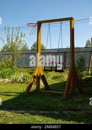 oscillazione fatta in casa in legno nel villaggio, in primavera Foto Stock