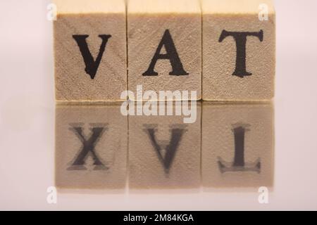 Blocco cubo in legno con testo IVA con riflesso speculare DELLA TASSA. Concetto finanziario, gestionale, economico, commerciale Foto Stock