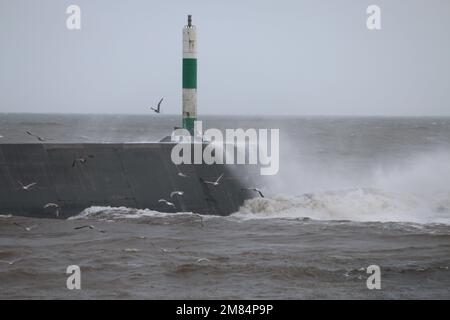 Aberystwyth Wales Italia meteo 12th Gennaio 2023 . Venti feroci colpiscono la costa gallese con un mare tempestoso che porta in onde giganti che sfondano contro il faro e la passeggiata del porto. Credit: mike davies/Alamy Live News Foto Stock