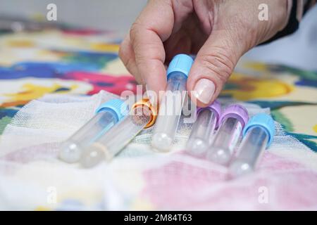 la mano di una donna che raccoglie un tubo di sangue. Donazione di sangue Foto Stock