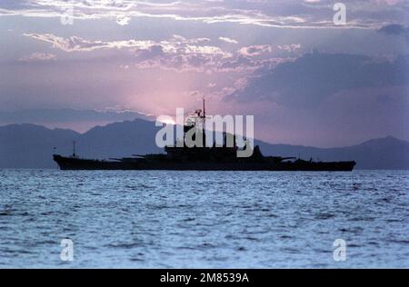 Una vista dal fascio del porto dalla silhouette della nave da guerra USS IOWA (BB-61) ancorata al tramonto. Base: Puerto Caldera Paese: Costa Rica (CRI) Foto Stock