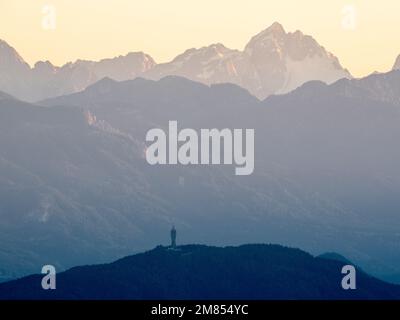 Un bellissimo scatto di Pyramidenkogel torre con lo sfondo dei paesaggi delle Alpi Giulie in Carinzia, Austria Foto Stock