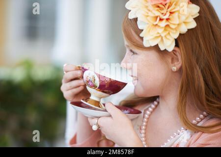 OH, mi piace il tè. Una bambina che gioca vestire e avere una festa del tè nel suo giardino. Foto Stock