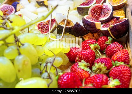 Fichi freschi a fette con fragole e uva verde. Messa a fuoco selettiva. Foto Stock