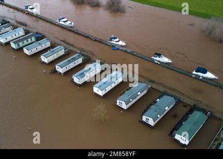 Kempsey, Worcestershire, 12 gennaio 2023 - le carovane natalizie presso il campo ricreativo di Seaborne a Kempsey, Worcestershire sono state abbandonate dall'acqua alluvionale dopo che il fiume Severn ha fatto esplodere le sue sponde. Le carovane statiche rialzate hanno ora la vista di un grande specchio d'acqua e di imbarcazioni da diporto ormeggiate fuori portata. Si prevede che il livello del fiume raggiunga il picco il sabato. Credito: Interrompi stampa Media/Alamy Live News Foto Stock