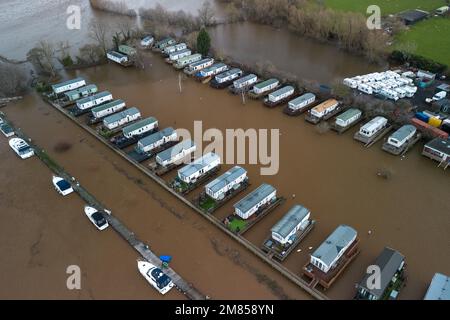 Kempsey, Worcestershire, 12 gennaio 2023 - le carovane natalizie presso il campo ricreativo di Seaborne a Kempsey, Worcestershire sono state abbandonate dall'acqua alluvionale dopo che il fiume Severn ha fatto esplodere le sue sponde. Le carovane statiche rialzate hanno ora la vista di un grande specchio d'acqua e di imbarcazioni da diporto ormeggiate fuori portata. Si prevede che il livello del fiume raggiunga il picco il sabato. Credito: Interrompi stampa Media/Alamy Live News Foto Stock