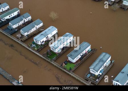 Kempsey, Worcestershire, 12 gennaio 2023 - le carovane natalizie presso il campo ricreativo di Seaborne a Kempsey, Worcestershire sono state abbandonate dall'acqua alluvionale dopo che il fiume Severn ha fatto esplodere le sue sponde. Le carovane statiche rialzate hanno ora la vista di un grande specchio d'acqua e di imbarcazioni da diporto ormeggiate fuori portata. Si prevede che il livello del fiume raggiunga il picco il sabato. Credito: Interrompi stampa Media/Alamy Live News Foto Stock