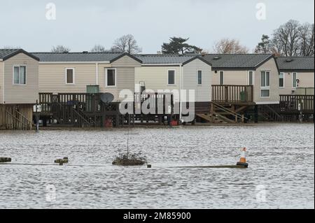 Kempsey, Worcestershire, 12 gennaio 2023 - le carovane natalizie presso il campo ricreativo di Seaborne a Kempsey, Worcestershire sono state abbandonate dall'acqua alluvionale dopo che il fiume Severn ha fatto esplodere le sue sponde. Le carovane statiche rialzate hanno ora la vista di un grande specchio d'acqua e di imbarcazioni da diporto ormeggiate fuori portata. Si prevede che il livello del fiume raggiunga il picco il sabato. Credito: Interrompi stampa Media/Alamy Live News Foto Stock