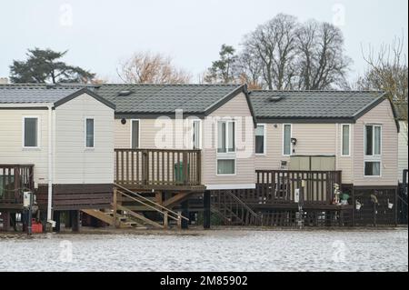 Kempsey, Worcestershire, 12 gennaio 2023 - le carovane natalizie presso il campo ricreativo di Seaborne a Kempsey, Worcestershire sono state abbandonate dall'acqua alluvionale dopo che il fiume Severn ha fatto esplodere le sue sponde. Le carovane statiche rialzate hanno ora la vista di un grande specchio d'acqua e di imbarcazioni da diporto ormeggiate fuori portata. Si prevede che il livello del fiume raggiunga il picco il sabato. Credito: Interrompi stampa Media/Alamy Live News Foto Stock