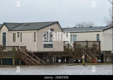 Kempsey, Worcestershire, 12 gennaio 2023 - le carovane natalizie presso il campo ricreativo di Seaborne a Kempsey, Worcestershire sono state abbandonate dall'acqua alluvionale dopo che il fiume Severn ha fatto esplodere le sue sponde. Le carovane statiche rialzate hanno ora la vista di un grande specchio d'acqua e di imbarcazioni da diporto ormeggiate fuori portata. Si prevede che il livello del fiume raggiunga il picco il sabato. Credito: Interrompi stampa Media/Alamy Live News Foto Stock