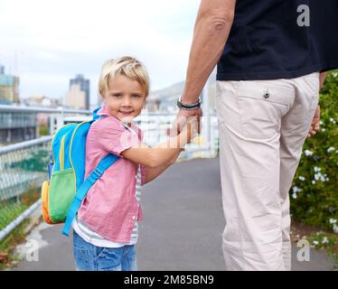 Mio padre è in prima posizione. Ritratto di un giovane ragazzo e di suo padre che cammina mano in mano. Foto Stock