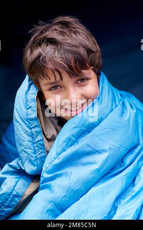 Svegliati con una nuova day...camping rocce. Ritratto di un ragazzo avvolto nel sacco a pelo. Foto Stock