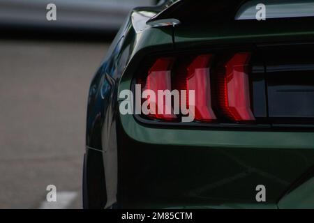 Primo piano della luce di posizione posteriore sinistra su un Mustang verde. Foto Stock