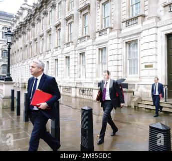 Londra, Regno Unito, Downing St. 12 gennaio 2023 Steve Barclay, Segretario di Stato per la salute, e John Glen, Segretario Capo del Tesoro, lasciano l'Ufficio del Gabinetto questa mattina, e camminano sotto la pioggia, a seguito di una lunga riunione dei ministri del governo BridgetCatterall/AlamyLiveNews Foto Stock