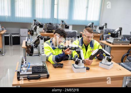 Il tecnico impara la teoria di base su come eseguire la manutenzione e programmare il braccio del robot nell'aula di formazione Foto Stock