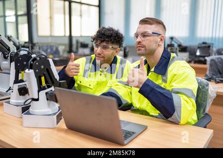 Il tecnico impara la teoria di base su come eseguire la manutenzione e programmare il braccio del robot nell'aula di formazione Foto Stock