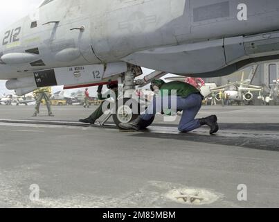 Gli equipaggi della piattaforma di volo attaccano un aereo F-14A Tomcat ad una catapulta durante le operazioni di volo a bordo della portaerei nucleare USS CARL VINSON (CVN-70). Paese: Oceano Pacifico (POC) Foto Stock