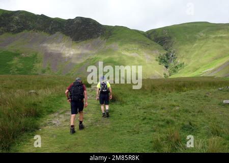 Due uomini camminano su un sentiero per Cautley Spout Waterfall & Crag nelle Howgill Fells vicino Sedbergh nel Yorkshire Dales National Park, Inghilterra, Regno Unito. Foto Stock