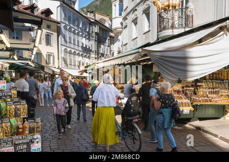 Mercato di Bolzano, vista in estate delle persone che passeggiano davanti alle bancarelle di Piazza Erbe, il principale mercato alimentare del centro storico di Bolzano Foto Stock