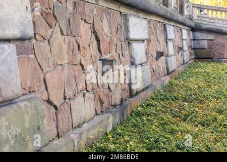 Un canale di drenaggio in pietra che sporge dalla parete. Foto Stock