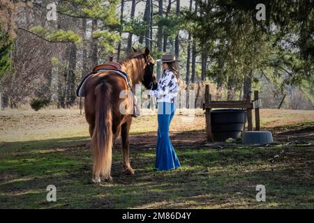 Ft Mill, SC, Stati Uniti. 11th Jan, 2023. Una bella cowgirl brunetta posa con il suo cavallo prima di andare in campagna (Credit Image: © Walter G. Arce Sr./ZUMA Press Wire) SOLO PER USO EDITORIALE! Non per USO commerciale! Foto Stock