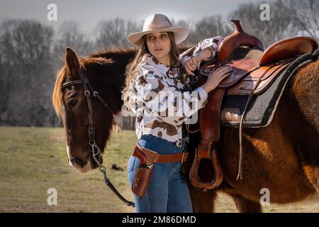 Ft Mill, SC, Stati Uniti. 11th Jan, 2023. Una bella cowgirl brunetta posa con il suo cavallo prima di andare in campagna (Credit Image: © Walter G. Arce Sr./ZUMA Press Wire) SOLO PER USO EDITORIALE! Non per USO commerciale! Foto Stock