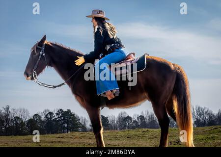 Ft Mill, SC, Stati Uniti. 11th Jan, 2023. Una bella cowgirl brunetta posa con il suo cavallo prima di andare in campagna (Credit Image: © Walter G. Arce Sr./ZUMA Press Wire) SOLO PER USO EDITORIALE! Non per USO commerciale! Foto Stock