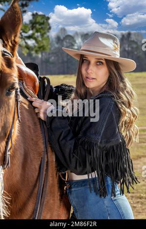 Ft Mill, SC, Stati Uniti. 11th Jan, 2023. Una bella cowgirl brunetta posa con il suo cavallo prima di andare in campagna (Credit Image: © Walter G. Arce Sr./ZUMA Press Wire) SOLO PER USO EDITORIALE! Non per USO commerciale! Foto Stock