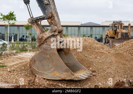 La benna di una macchina da costruzione che lavora nel fango. Benna dell'escavatore a terra. Foto Stock