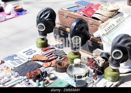 Interessanti oggetti d'epoca e souvenir militari georgiani e russi in vendita al mercato delle pulci all'aperto, al mercato di Dry Bridge nel centro di Tbilisi, Georgia Foto Stock