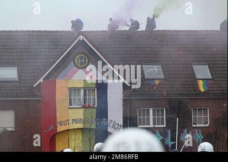 Erkelenz, Germania. 12th Jan, 2023. Gli attivisti accendono i pirotecnici sul tetto. Credit: Henning Kaiser/dpa/Alamy Live News Foto Stock