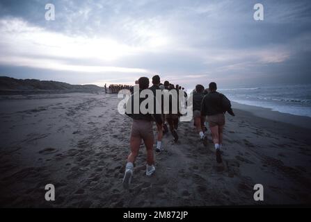 Gli studenti corrono giù Coronado Beach in una doppia colonna durante la formazione di base sulla demolizione subacquea/TENUTA (BUD/S). Base: San Diego Stato: California (CA) Paese: Stati Uniti d'America (USA) Foto Stock