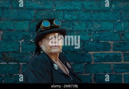 Ritratto di una donna più anziana steampunk che indossa un cappello con occhiali attaccati. Foto Stock