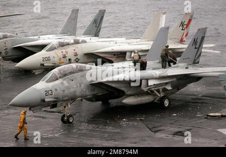 Gli equipaggi di movimentazione aerei spazzolano neve e ghiaccio dalle ali di un aereo Fighter Squadron 111 (VF-111) F-14A Tomcat durante le operazioni di volo a bordo della portaerei nucleare USS CARL VINSON (CVN-70). Paese: Oceano Pacifico settentrionale Foto Stock