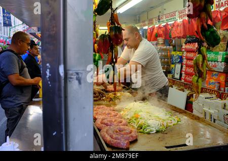 Un fornitore di cibo che grigliano salsicce italiane in Little Italy durante il San Gennaro Festival.Manhattan.New York City.USA Foto Stock