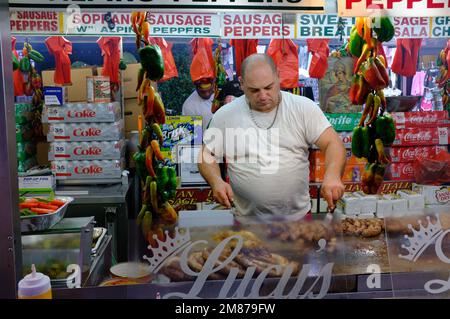 Un fornitore di cibo che grigliano salsicce italiane in Little Italy durante il San Gennaro Festival.Manhattan.New York City.USA Foto Stock