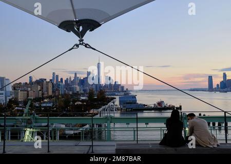 La vista del Fiume Hudson e dello skyline di Lower Manhattan con Jersey City a distanza dal Molo 57 Rooftop Park con Visitors.Manhattan.New York City.USA Foto Stock