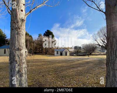 Municipio del villaggio di Cardrona con prato erboso e una recinzione da picnic vista attraverso alberi. Foto Stock