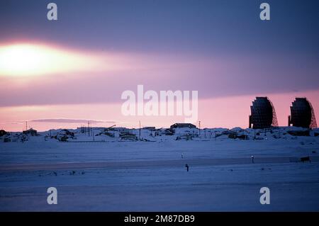 Il sole tramonta dietro una stazione radar. La stazione è una delle 30 sotto gli Stati Uniti Controllo delle forze aeree sulla linea di allerta precoce (RUGIADA) che corre circa 3.600 miglia, dall'Alaska, attraverso il Canada settentrionale alla Groenlandia. Base: Barter Island Stato: Alaska (AK) Nazione: Stati Uniti d'America (USA) Foto Stock