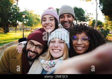 Selfie ritratto di un gruppo di giovani multirazziali che si divertono in un viaggio in vacanza. Vista frontale di amici cheergul godendo insieme il fine settimana. Foto di alta qualità Foto Stock