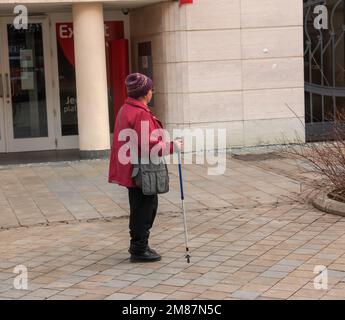 Nitra, Slovacchia - 01.06.2023: Una donna matura con bastoni da nordic walking cammina per le strade della città. Il concetto di uno stile di vita sano. Foto Stock