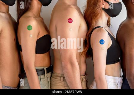 Vaccinazione di sicurezza. giovani uomini e donne vaccinati su sfondo bianco studio. mostra braccio dopo l'iniezione del vaccino. Coronavirus, Covid-19, influenza Foto Stock