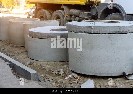 Tubi in calcestruzzo per costruire sistemi di drenaggio su grandi tubi di drenaggio del cemento per la costruzione di edifici industriali, fuoco selettivo. Foto Stock