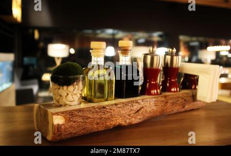 Bottiglie in vetro con agitatori per olio, aceto, sale e pepe su Un tavolo Foto Stock