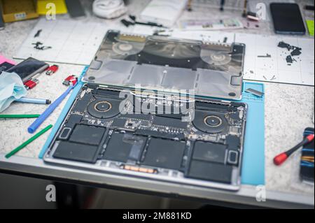 Supporto tecnico e risoluzione dei problemi relativi ai gadget. Manutenzione, riparazione, pulizia, manutenzione dei calcolatori. Officina di riparazione. Manutenzione hardware. Tecnici maschili Foto Stock